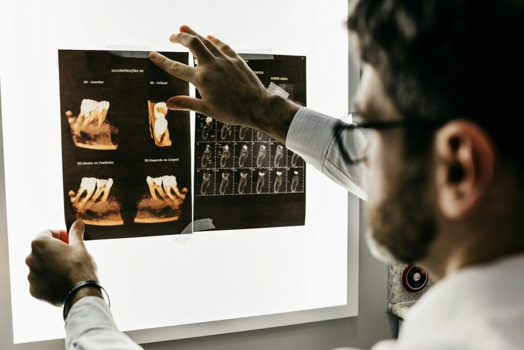 Dentist examining dental X-ray films on an illuminated viewing panel
